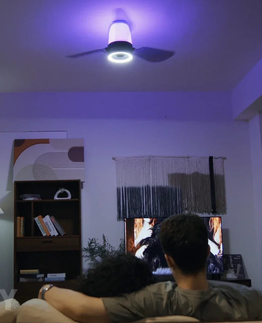 Ceiling fan with integrated speaker system and built-in lighting in a modern room.